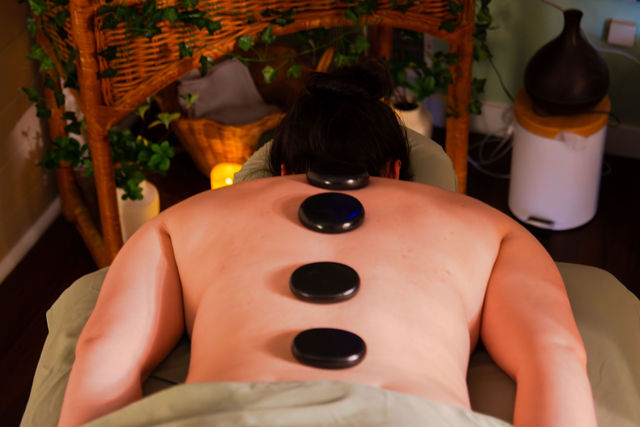 Heated basalt stones placed along the spine during a hot stone massage